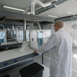 man in white laboratory gown standing near white and black machine